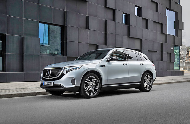 A light grey Mercedes Benz EQC parked on a city street