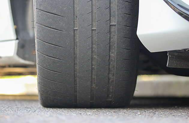 A close up of a car tyre that has worn rubber tread