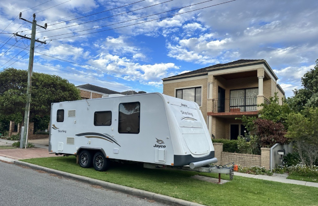 Caravan parked outside house on verge