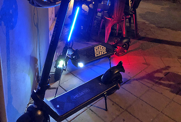 Colourful strip lights on an e-scooter at night