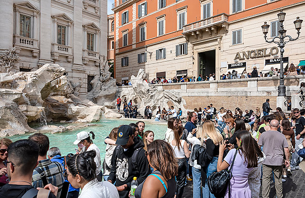 Crowds of tourists around the Trevi Fountain in Rome