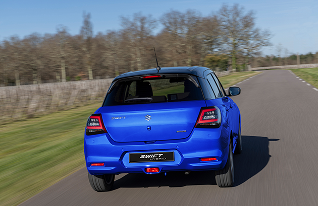 The rear of a 2024 Suzuki Swift driving down a road