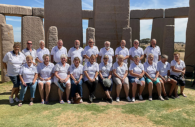 A large group pose for a photo in front of Esperance Stonehenge