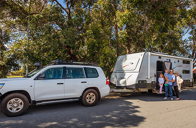 A family pose in front of their caravan