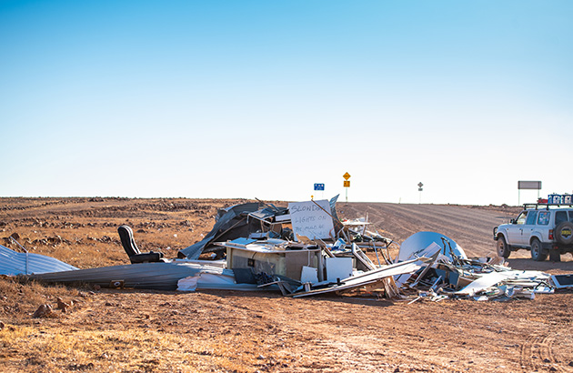 Debris of a destroyed caravan along the side of a road