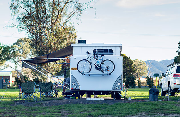 A caravan parked in a caravan park seen from the rear