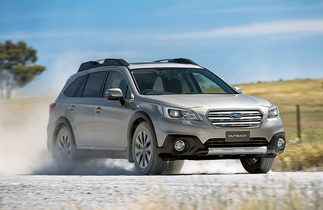 A white Subaru driving on a dirt track