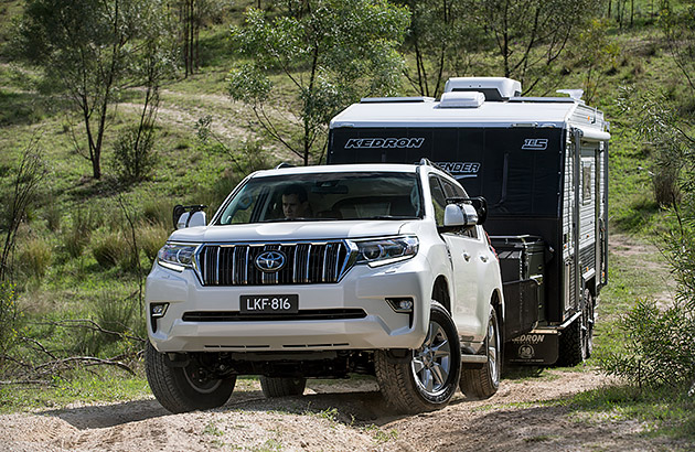 A white Toyota Prado on a bush track