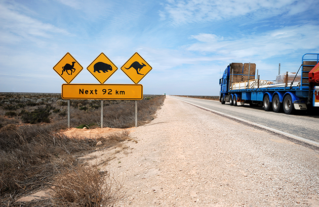 A truck passing warning signs on the highway