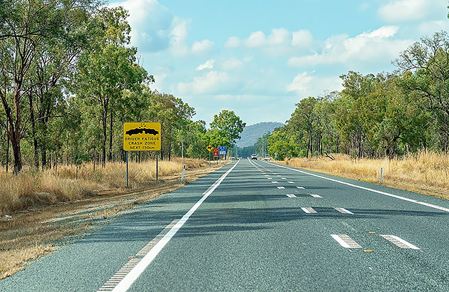 A country road showing a Driver Fatigue Crash Zone sign