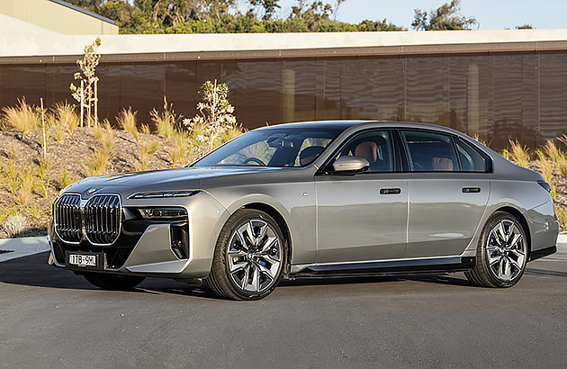 A silver BMW i7 parked in front of a home