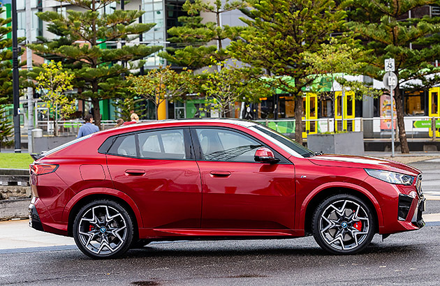 A red BMW ix2 parked on a city street