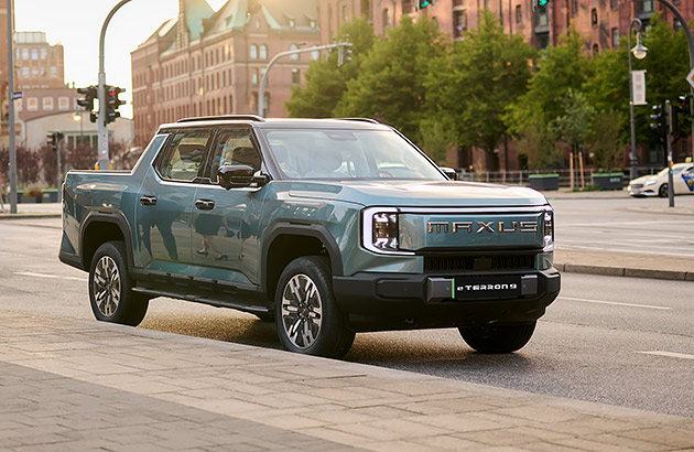 A green Maxus eTerron driving on a city street