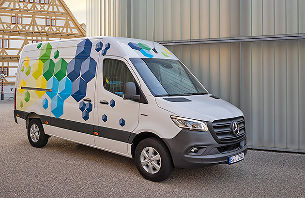 A white Mercedes Benz eSprinter van with painted with colourful geometric shapes