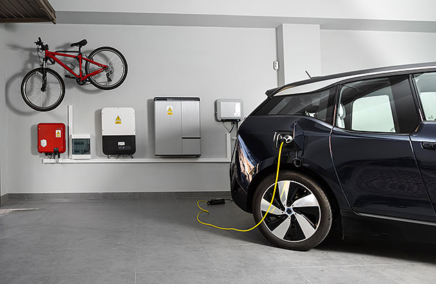 An EV plugged into a wall box in a garage
