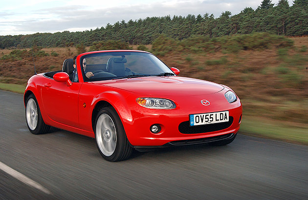 A red Mazda MX-5 on a country road