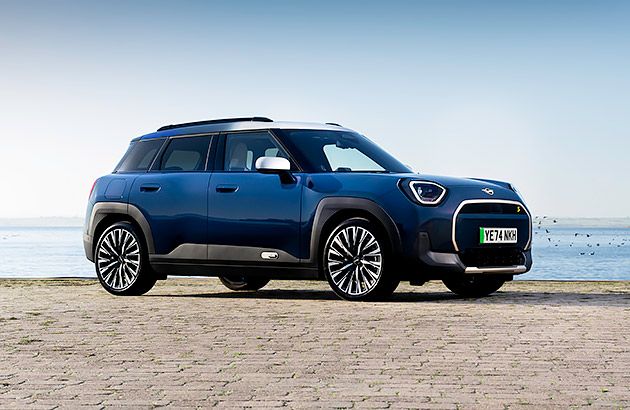 A dark blue Mini Aceman parked near a beach