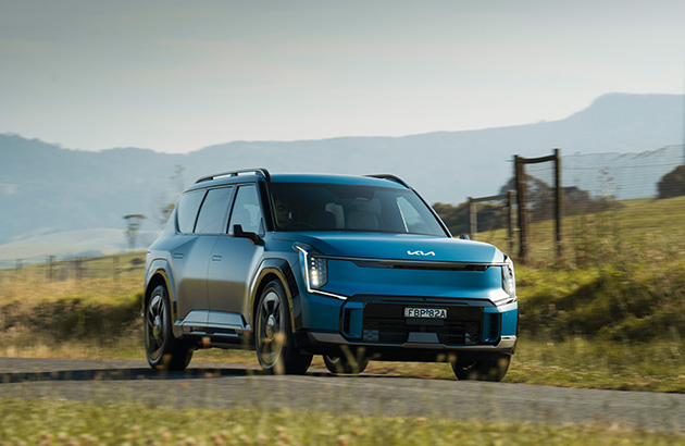 Kia EV9 driving down a country road