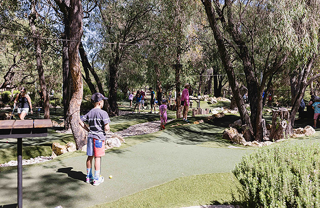 Children and adults on the mini golf course at Par 3