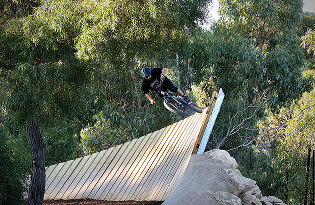 A mountain bike rider on a high wooden berm at Boo Park in Fremantle