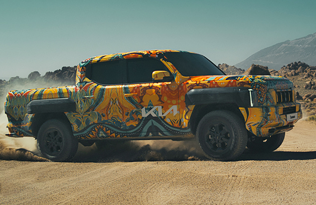 A Kia Tasman ute travelling on sand