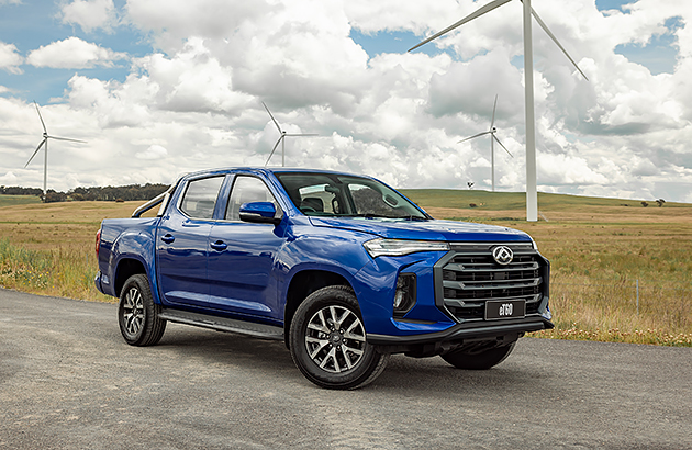 A blue LDV-eT60n ute on a country road with wind turbines in the distance