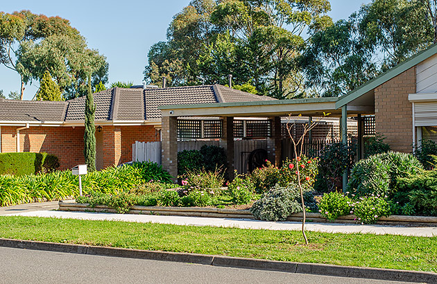 A frontage of a suburban home showing the verge and a public path