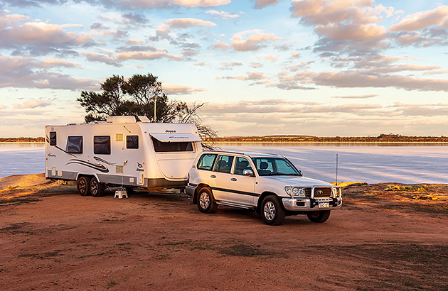 A four-wheel drive towing a caravan near a saltlake