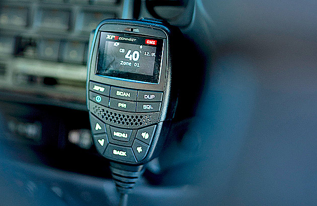 A close-up of a UHF radio handset in a car