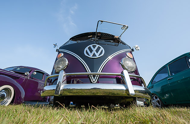 A purple VW Kombi Van viewed from the front