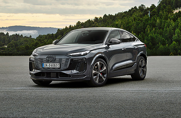 A black Audi eTron6 parked on a tarmac in a country setting