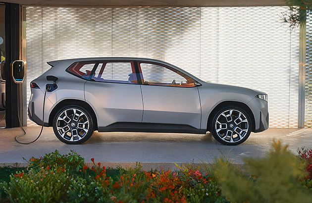 A grey BMW Vision parked in front of a modern home