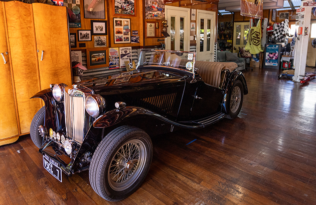 A black 1947 MG TC parked in a garage