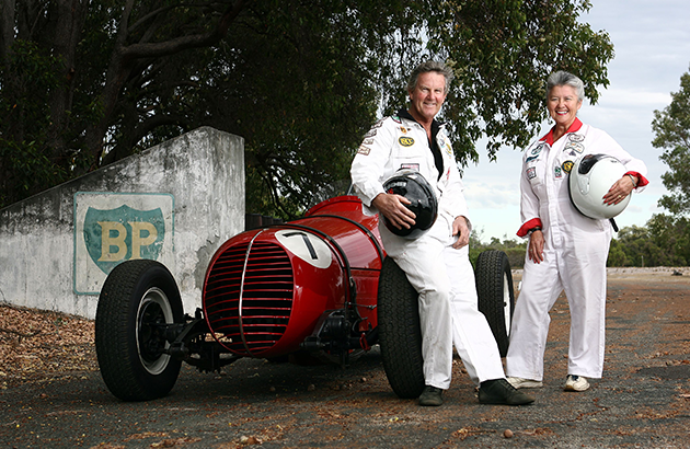 Ken and Mary Ann pose with a red racing car