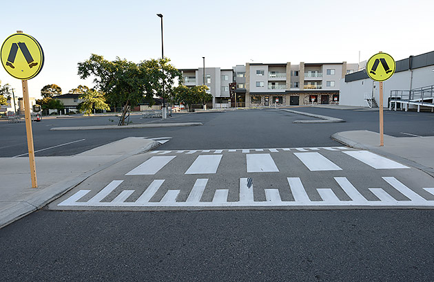 A speed hump in a shopping centre carpark with a pedestrian crossing