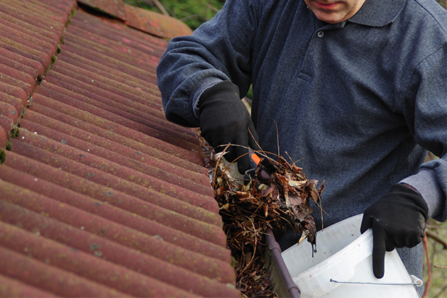 Image of man cleaning gutter