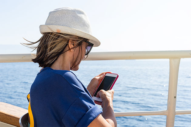 Image of woman using phone on a cruise