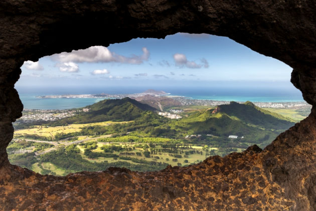 Pali Puka lookout in Oahu, a view through rock of the surrounding area
