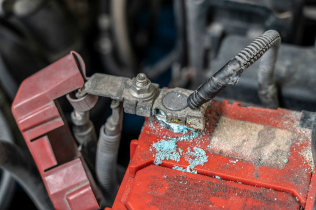 A close up of a corroded car battery