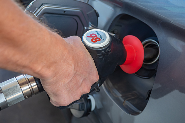 Image of person filling car with petrol using pump