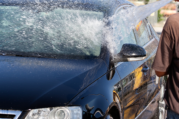 Image of man hosing down car