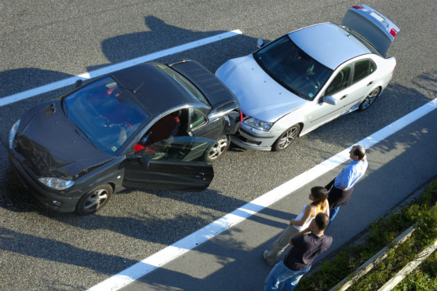 Two cars parked on the side of a road after a car crash