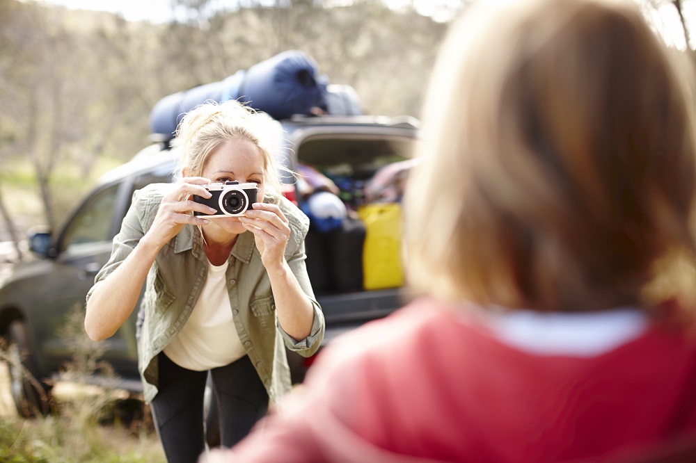 Mum taking photo of child on road trip pit stop