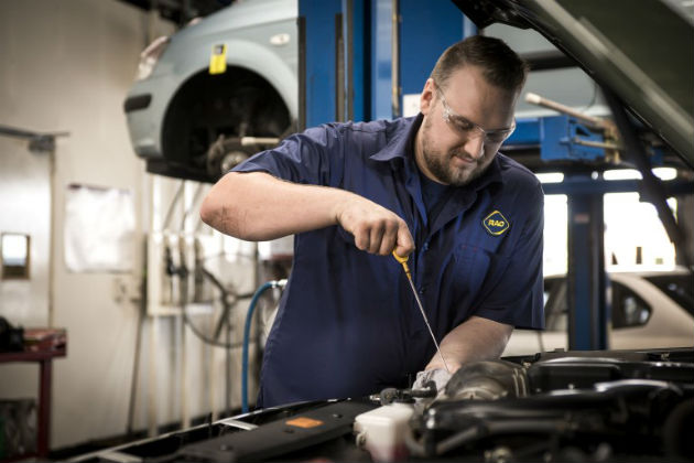 A mechanic looking at a dipstick