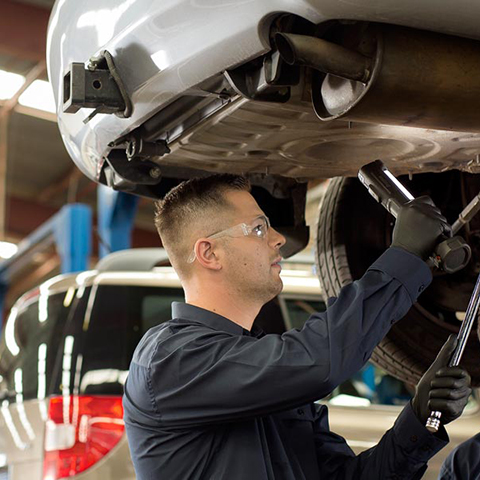 An RAC mechanic is inspecting the underside of a vehicle