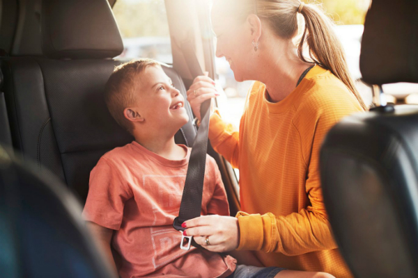 parent buckling child into car