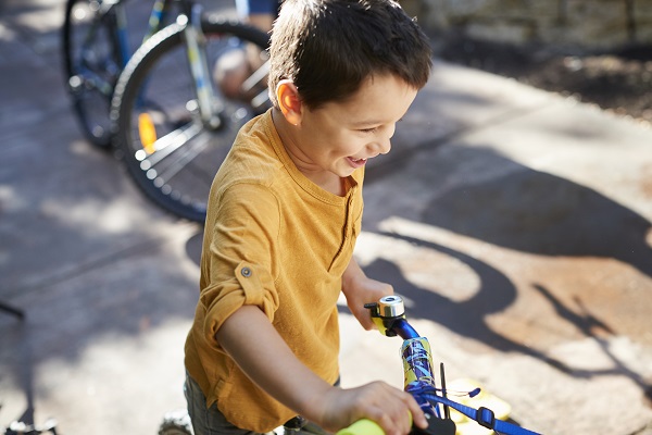 Young boy smiling whilst getting ready to ride his pushbike