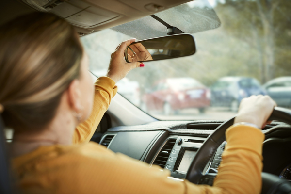 parent checking rear vision mirror whilst driving