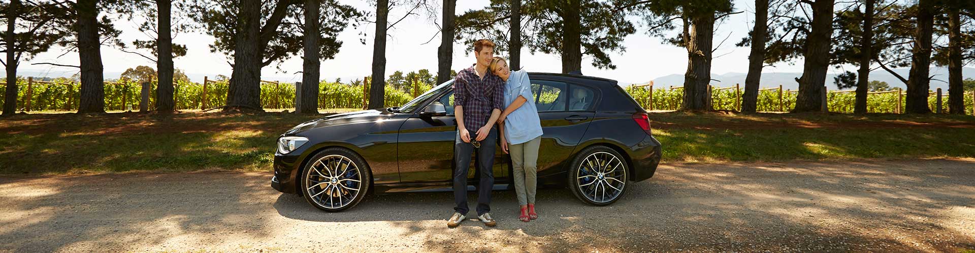 Couple standing by their car. 