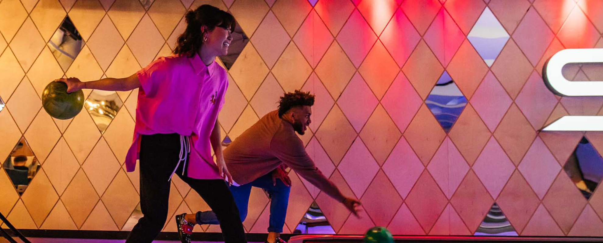 Man and a woman rolling a bowling ball